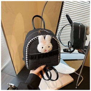 Detail of a mini denim backpack with lace trim, checkered piping, and a 3D plush rabbit head
