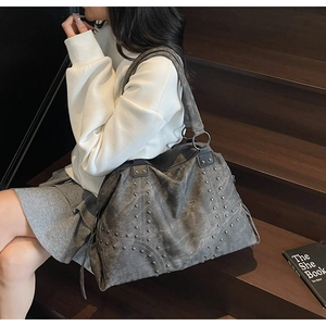 Detail of the vintage gray washed leather tote bag with stylish metal rivet decorations