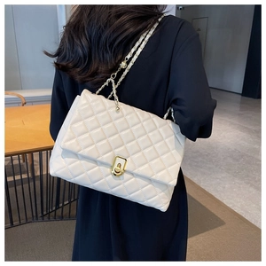 Close-up of beige quilted bag showing golden chain strap with ball adjustment detail
