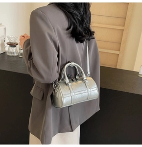 Sac bandoulière argenté métallisé porté par un mannequin dans un cadre moderne chic
