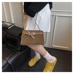Gros plan d'un sac à bandoulière en cuir dépoli marron avec boucle décorative