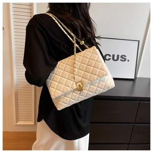 Detail of white quilted crossbody bag with golden chain and metallic twist lock clasp
