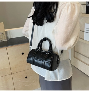 Détails du sac cylindrique noir minimaliste avec texture cuir et finitions argentées