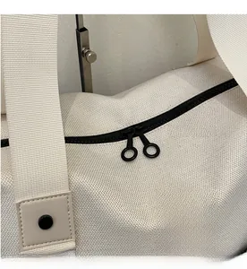 Close-up of smooth black double zippers and logo patch on durable canvas duffel bag