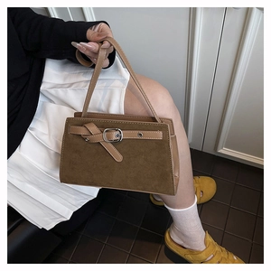 Détail du sac bandoulière marron en daim mat et cuir avec boucle décorative argent