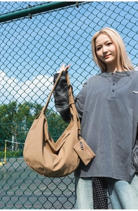 Khaki large nylon dumpling bag with matching mini pouch shown on model in outdoor setting