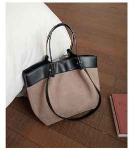 Detail of a large capacity tote bag featuring brown suede and black leather patchwork