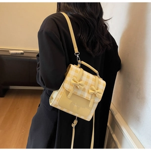 Dettaglio dello zaino a scacchi gialli con fiocchi indossato sul retro di una modella