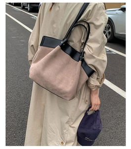 Detail view of large color-block tote bag with beige suede and black leather stitching