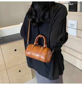 Sac Boston cylindrique marron porté à l'épaule en similicuir texturé au fini brillant