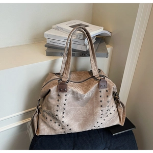 Close-up of vintage rivets and premium leather texture on large khaki tote bag