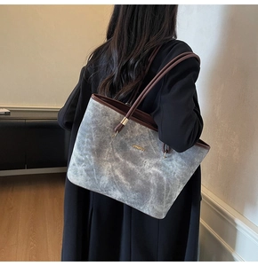 Detailed side view of a large marble-textured tote bag with premium leather straps