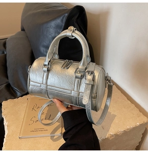 Gros plan détaillé du sac Boston argenté avec texture plissée et garnitures argentées