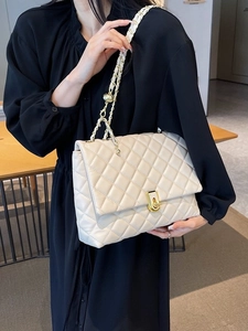 Elegant cream quilted crossbody bag with gold chain strap and rotary lock shown on model