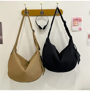 Detail of khaki and black nylon crescent bags with adjustable straps and coin pouches