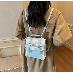 Dettaglio del mini zaino a quadretti con fiocchi indossato da una modella
