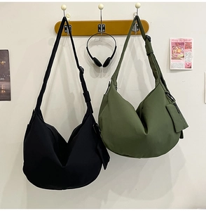 Detail of nylon crescent bags in black and army green with adjustable shoulder straps