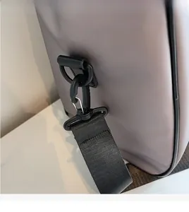Close-up of durable black shoulder strap hook on grey Oxford fabric handbag
