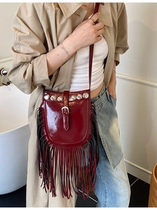 Fashionable wine red tassel bucket bag with metallic rivets and crossbody strap