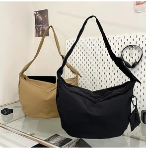 Close-up of khaki and black nylon hobo bags with a detachable small coin purse