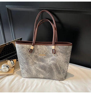 Detail of grey marble pattern tote bag with gold logo on vintage wood background