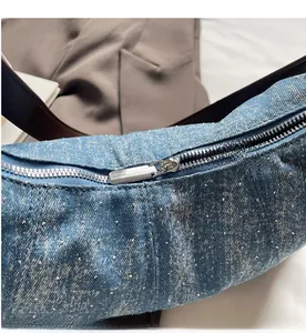 Detailansicht aus blauem Denim mit silbernen Nieten und glattem Metallreißverschluss