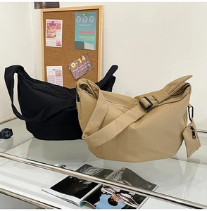 Detail of black and khaki nylon crescent bags with adjustable straps and coin purse
