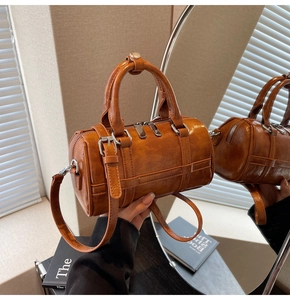 Détail de la texture du cuir ciré marron et de la fermeture éclair argentée du sac Boston