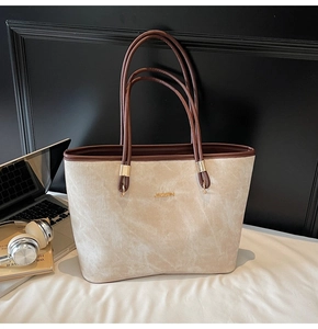 Macro detail of chic beige tote bag with vertical texture and gold metal ring connectors