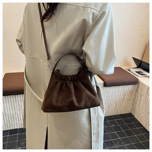 Vue détaillée du sac nuage en daim marron foncé avec design plissé et fine bandoulière