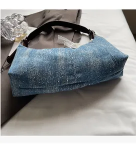 Details der blauen Denim-Hobo-Tasche mit glitzernden Strasssteinen und Perlenanhänger