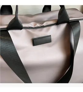 Close-up of lilac nylon oxford fabric with black strap details and rubber patch