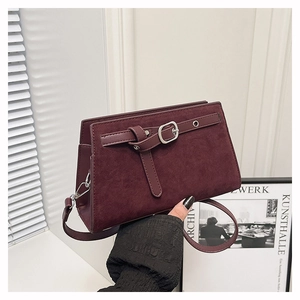 Détail du sac bandoulière en daim bordeaux avec boucle décorative argentée élégante