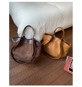 Detail of large suede and leather tote bags in dark brown and camel for daily commute