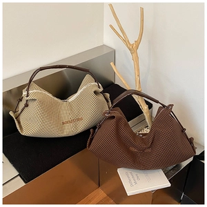 Detailed macro view of two minimalist half-moon tote bags in beige and brown plaid patterns
