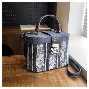 Blue denim box bag featuring white lace floral applique and brown leather trim detailing