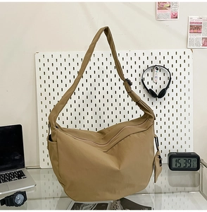 Detail of khaki nylon crescent bag with adjustable strap and mini coin pouch detail