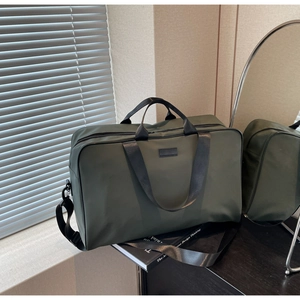 Macro shot of olive green nylon handbag with adjustable strap and black handles