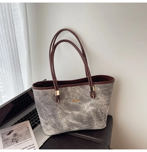 Detail of grey marble texture tote bag with brown straps and gold JINGPIN logo