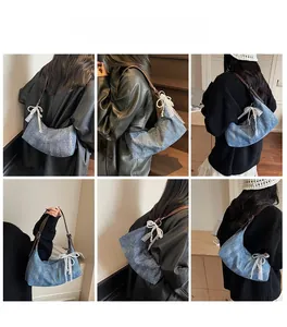 Blaue Denim-Hobo-Tasche mit Schleife und Perlenanhänger am Model gezeigt