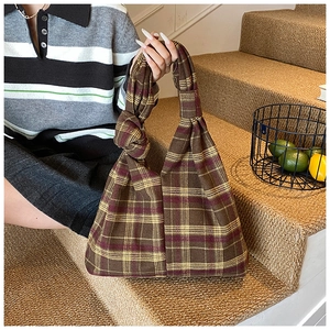Close-up of retro plaid tote bag with thick knitted texture and knotted handle detail
