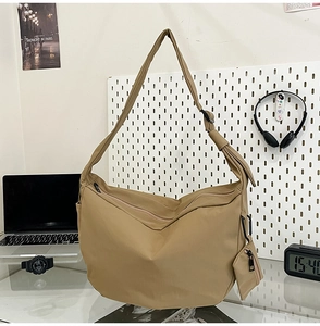 Detail of khaki nylon crescent bag with adjustable strap and small matching coin pouch