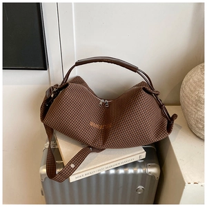 Detailed view of checkered hobo bag with dual metal zippers and leather handle straps