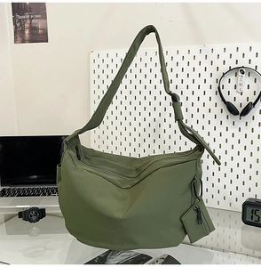 Olive green nylon crescent bag featuring a matching mini coin purse and wide shoulder strap