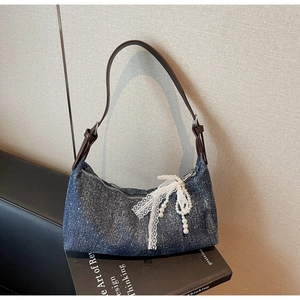Detail der blauen Denim-Tasche mit funkelnden Strasssteinen und Perlen-Schleifen