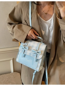 Elegante borsa a tracolla a quadretti celeste con fiocchi indossata da una modella