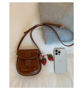 Retro brown leather saddle bag with strawberry charms and adjustable strap detail