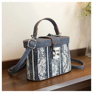 Close-up of box bucket bag with blue denim, white floral lace, and brown leather trim