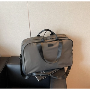 Detail of high-capacity dark grey waterproof oxford cloth bag on a leather sofa