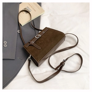 Détail du sac bandoulière vintage en daim marron avec boucle et lanière en cuir